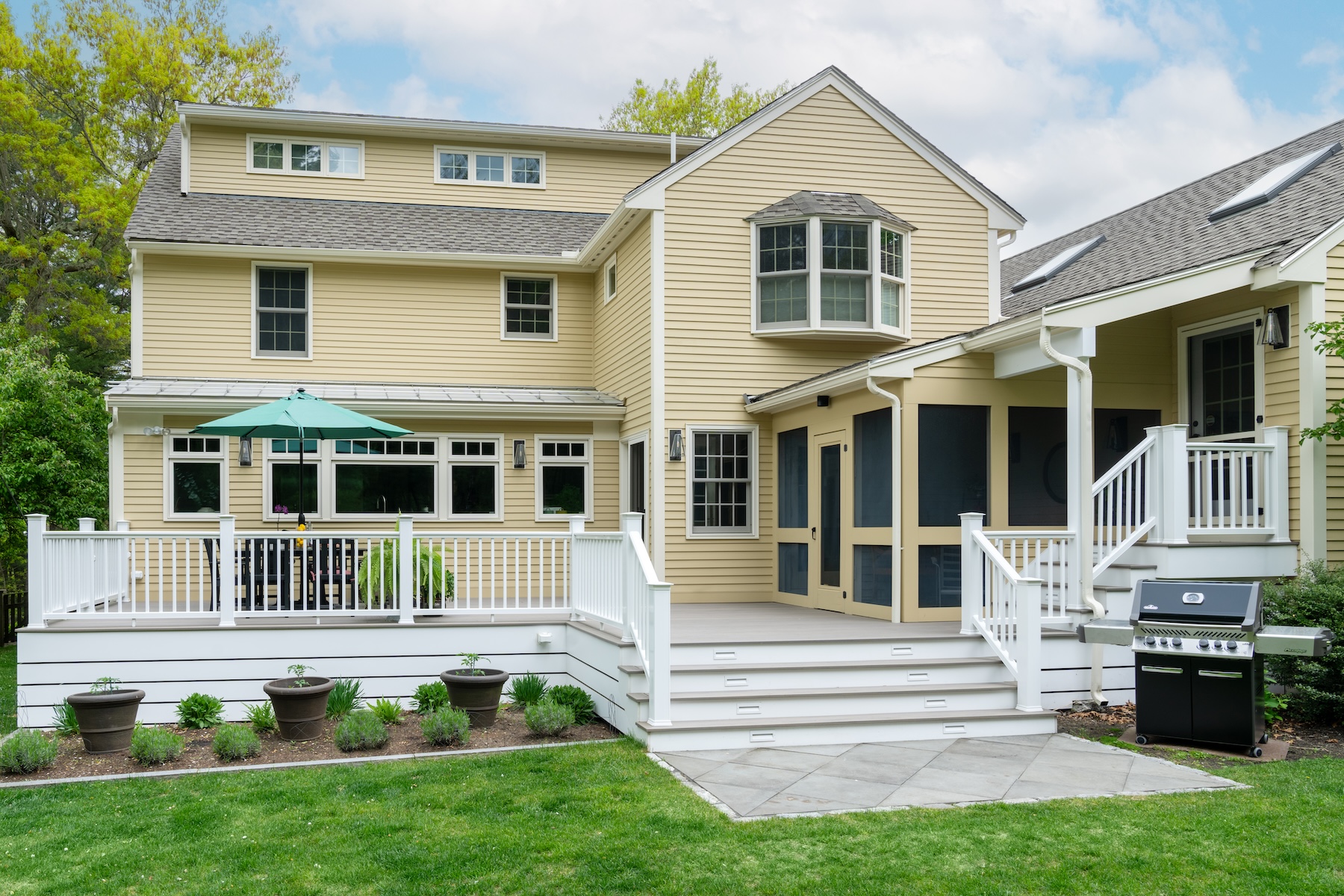 Home With Pale Yellow Siding And Large Multi Level Deck